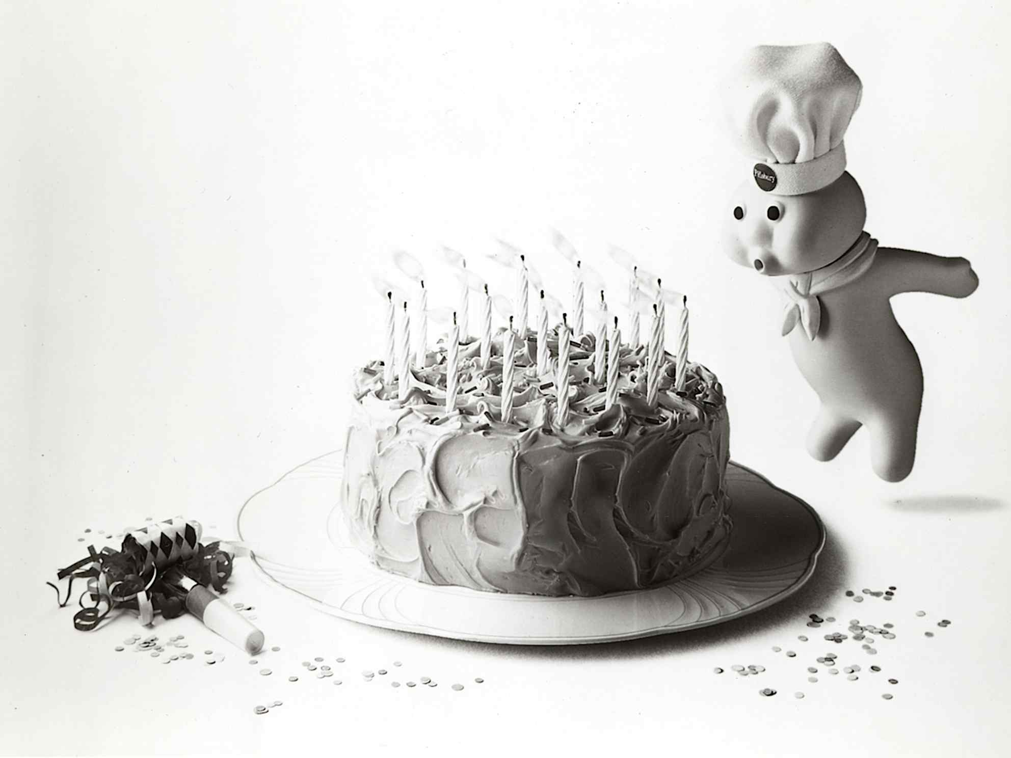 Pillsbury doughboy blowing out candles on a birthday cake